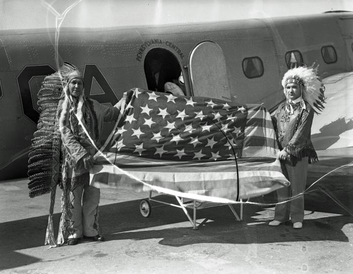 Native Americans with flag at airport